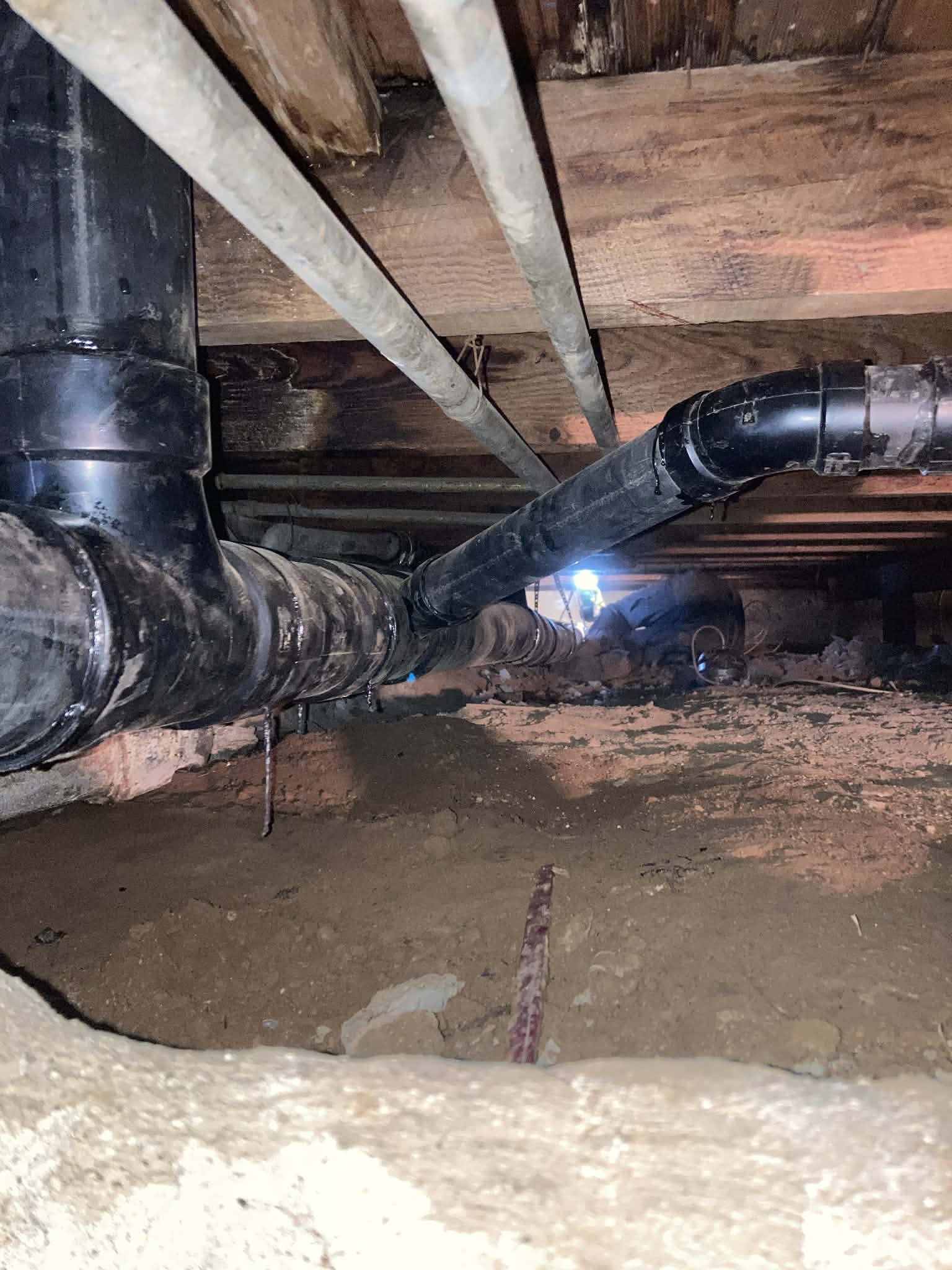 Crawl space plumbing installation with ABS drain pipes